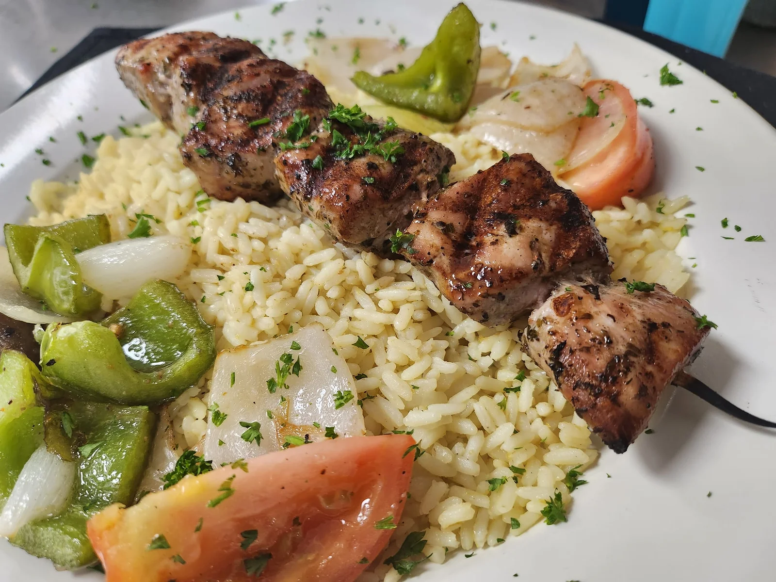 Grilled pork kabob with vegetables over rice pilaf